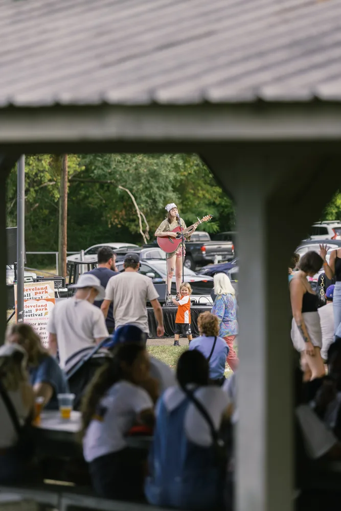 A view through the park shelter toward the music stage and audience.