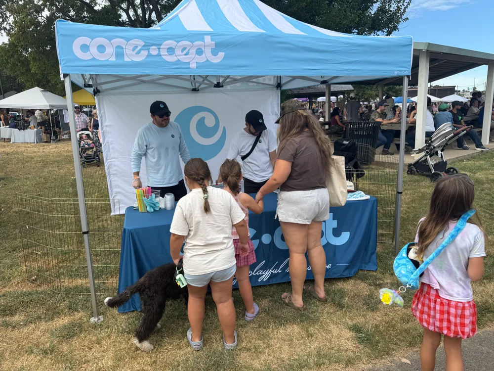 Families stopping at the blue Cone•cept tent for treats.